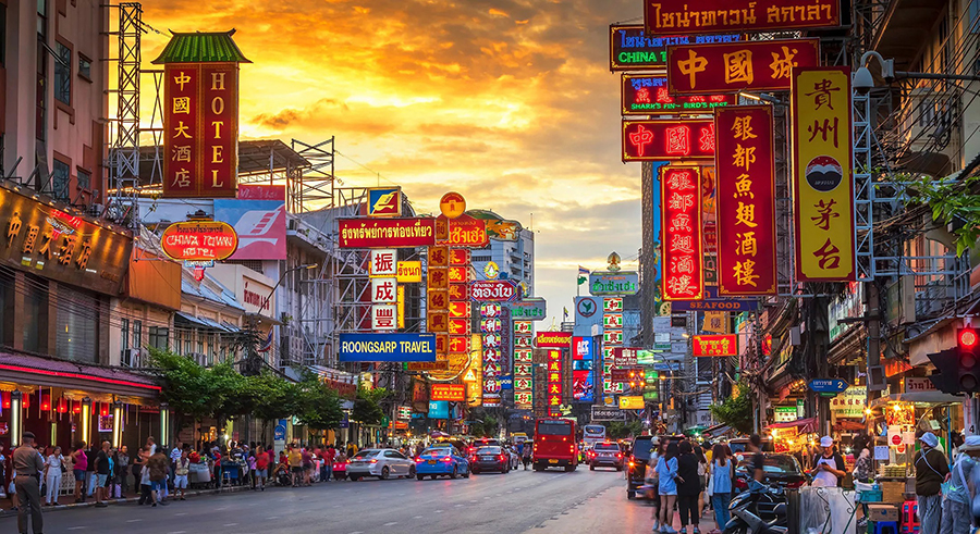 Explore neon-lit street food markets and iconic landmarks on your private Bangkok food tour. Bustling street food stalls and vibrant neon signboards along Chinatown Yaowarat road on a private Bangkok food tour