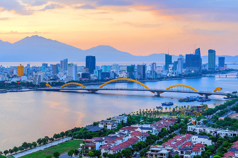 A panoramic view of Da Nang, Vietnam, showing its modern skyline, iconic bridges, and beautiful coastline at dusk A panoramic view of Da Nang, Vietnam, showing its modern skyline, iconic bridges, and beautiful coastline at dusk