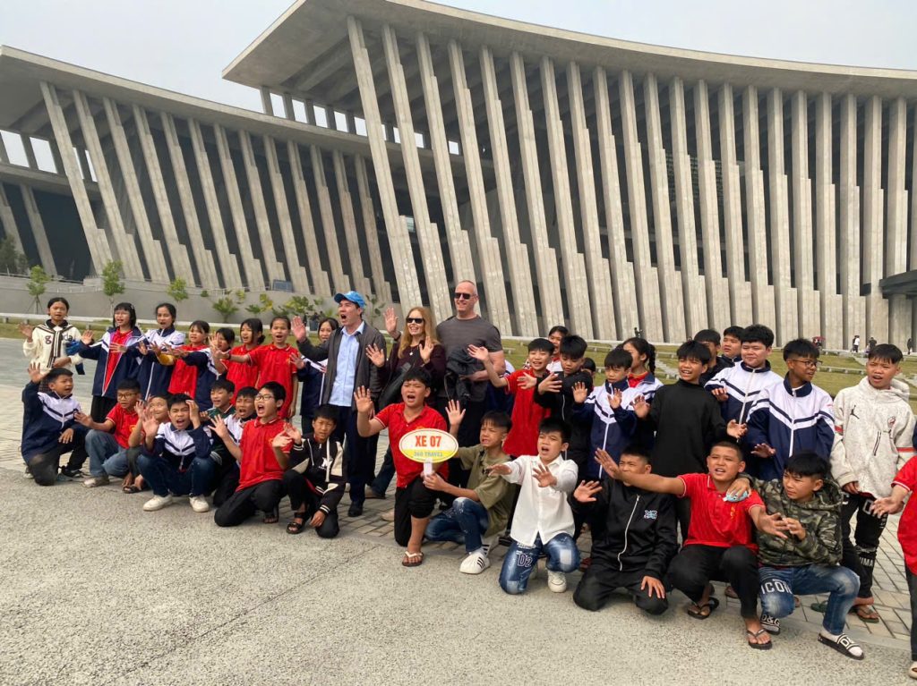 Customers enjoying a vibrant cultural exchange and chat with local students. Tourists engaging in friendly conversation with Vietnamese students.