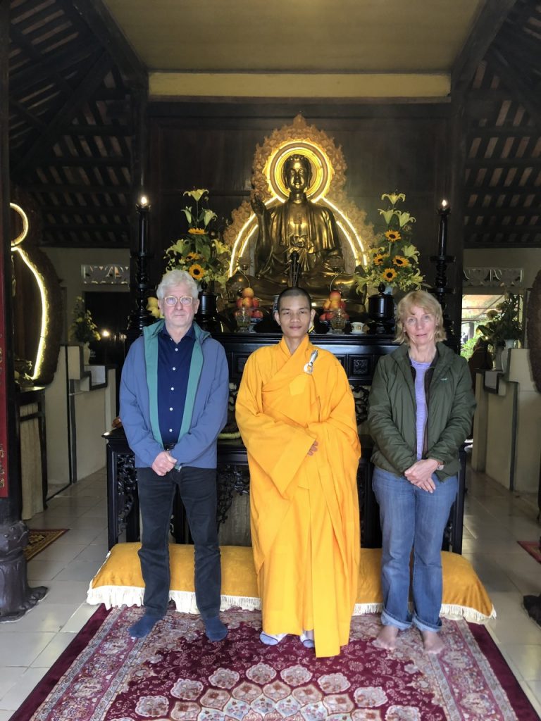 A serene and spiritual experience on our unforgettable Hue Buddhist tour. A group of tourists and a guide visiting a peaceful temple on a Hue Buddhist tour.