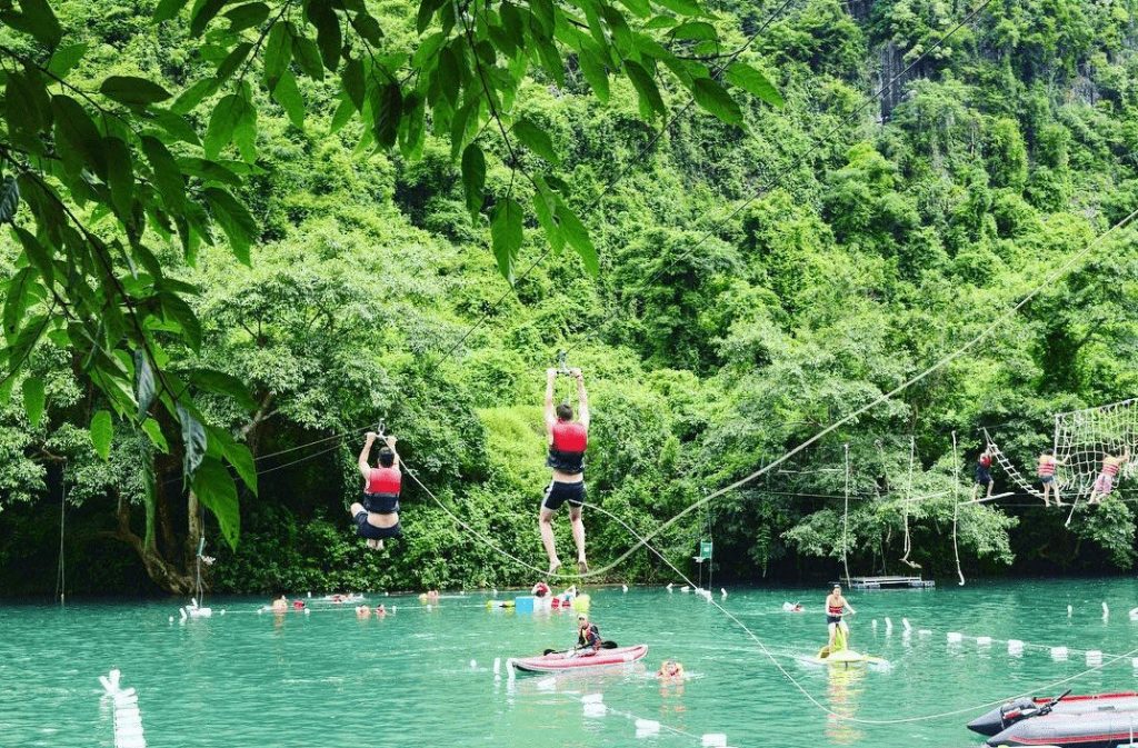 Tourists enjoying various water activities including ziplining and kayaking on the emerald Chay River near Dark Cave in Phong Nha. Tourists enjoying various water activities including ziplining and kayaking on the emerald Chay River near Dark Cave in Phong Nha.