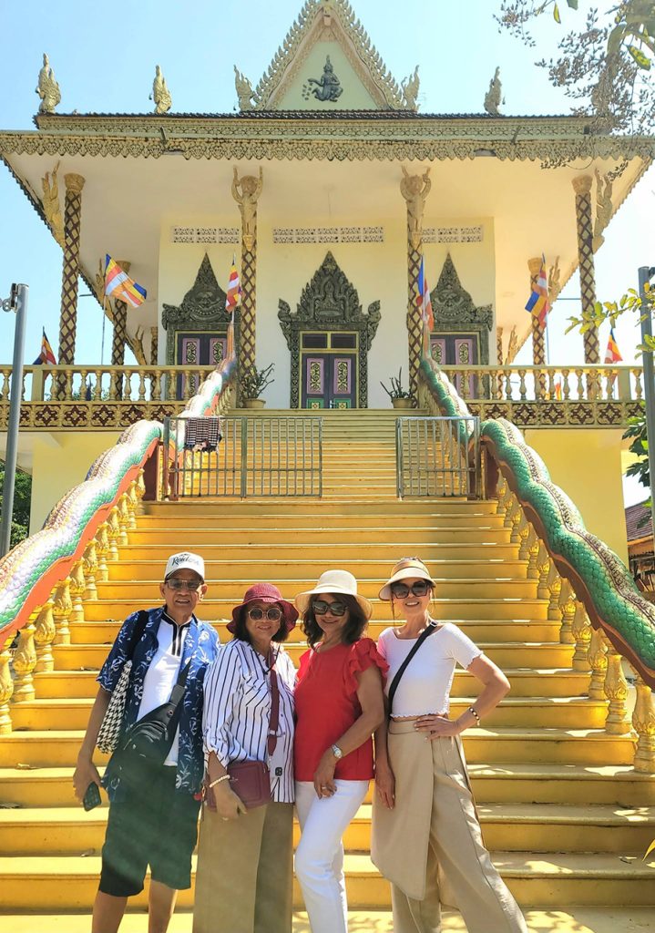 Happy cruise tourists exploring the ornate architecture and serene surroundings of Wat Leu pagoda in Sihanoukville during sihanoukville shore excursions.