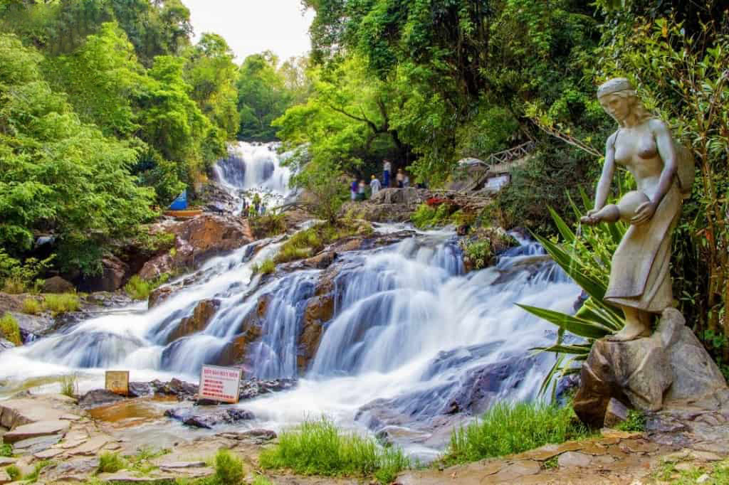 A wide view of the cascading white water at Datanla Waterfall surrounded by rocks.