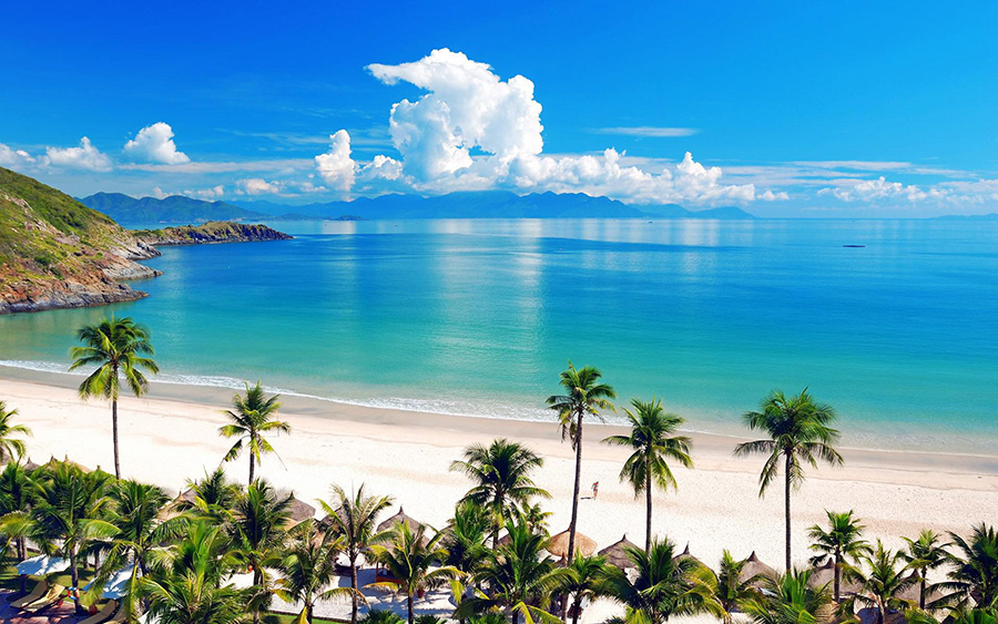 Scenic Nha Trang coastline featuring white sandy beaches, turquoise ocean water, and lush green mountain ranges on Nha Trang private city tour.