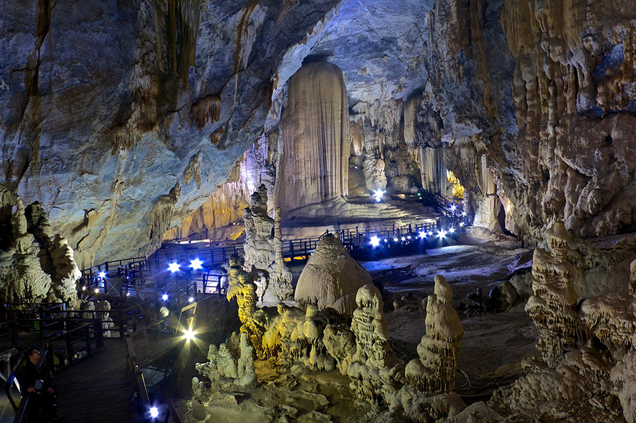 Inside the Paradise Cave, a surreal world of magnificent stalactites and stalagmites. Tourists on a boardwalk inside Paradise Cave, surrounded by massive rock formations.