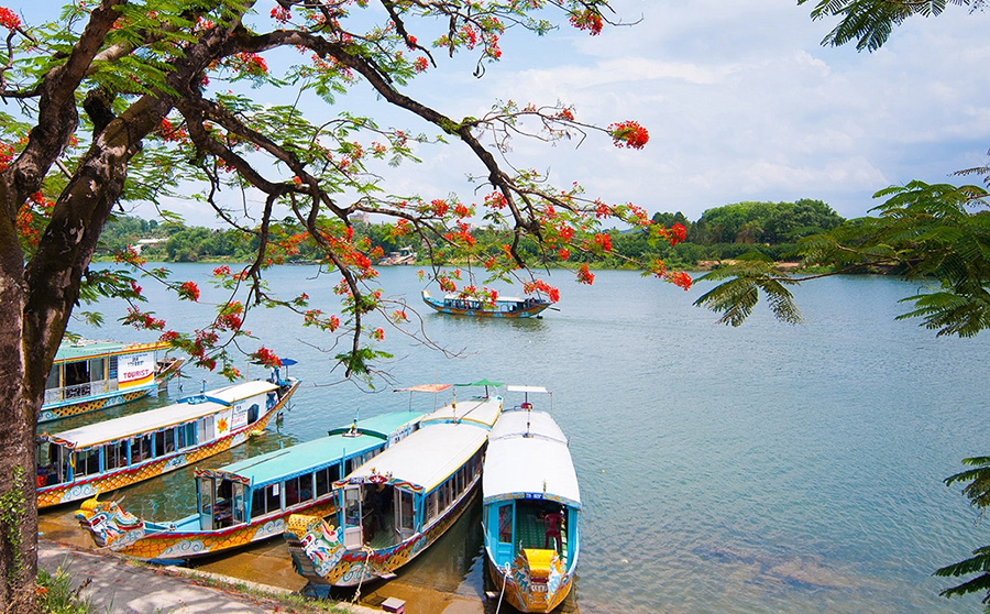 A peaceful cruise on the Perfume River, offering tranquil views of Hue’s scenic banks. A traditional dragon boat carrying tourists on a Perfume River cruise in Hue, Vietnam.