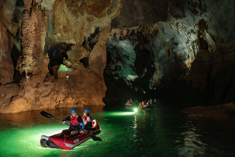 Paddling through an awe-inspiring labyrinth of illuminated stalactites and stalagmites in Phong Nha. A tourist kayaking on the tranquil, emerald waters of the Phong Nha cave.