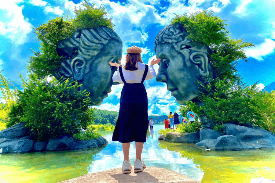 Stepping into a world of art! Our guests love exploring the incredible hand-carved sculptures today. Happy tourists exploring intricate red basalt clay sculptures at the famous Dalat Clay Tunnel park.